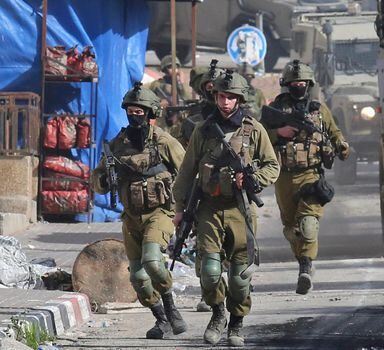 Israeli soldiers patrol on March 30, 2022 a village south of Jenin in the occupied West Bank, reportedly from where Palestinian assailant Diaa Hamarshah left before killing five people during a gun attack in Israel. - Israeli Prime Minister Naftali Bennett warned of a "wave of murderous Arab terrorism" ahead of funerals Wednesday for two of five people killed in a shooting rampage in an ultra-religious Jewish town. The shooting in Bnei Brak, a coastal town outside Tel Aviv, of four civilians and a police officer was the third fatal gun or knife attack in the Jewish state in the past week. (Photo by AFP)