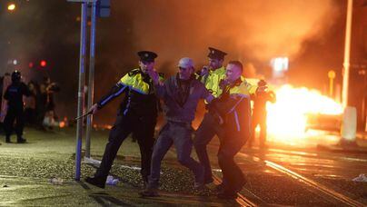 Polícia irlandesa prende homem em protesto anti-imigração em Dublin, em imagem desta quinta-feira, 23. Manifestantes de extrema direita foram às ruas após agressor esfaquear cinco pessoas Foto: Brian Lawless/via AP