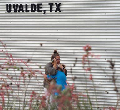 A woman cries and hugs a young girl while on the phone outside the Willie de Leon Civic Center where grief counseling will be offered in Uvalde, Texas, on May 24, 2022. - An 18-year-old gunman killed 14 children and a teacher at an elementary school in Texas on Tuesday, according to the state's governor, in the nation's deadliest school shooting in years. (Photo by Allison Dinner / AFP)