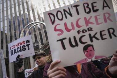 Manifestantes protestam com cartaz com a foto de Tucker Carlson em frente ao prédio da Fox News.