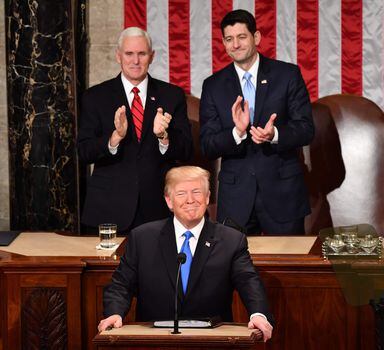 Donald Trump ouve e agradece os aplauosos durante o discurso do Estado da União no Congresso, com o vice-presidente Mike Pence (à esquerda) e o líder republicano Paul Ryan (à direita) ao fundo