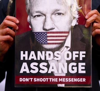 FILE PHOTO: A supporter of Julian Assange displays a placard, outside the Westminster Magistrates' Court in London, Britain April 20, 2022. REUTERS/Tom Nicholson/File Photo