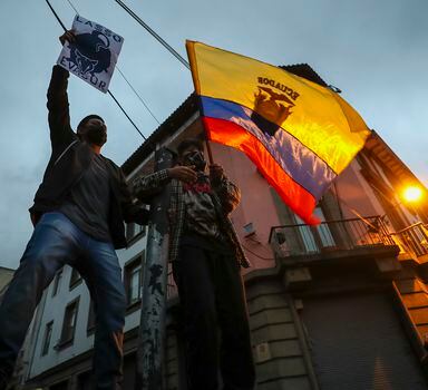 Manifestantes agitam bandeira equatoriana durante protestos contra o governo de Guillermo Lasso, em Quito.