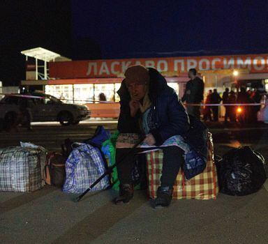 A passenger sits on bags as a convoy of 30 buses carrying evacuees from Mariupol and Melitopol arrive at the registration center in Zaporizhzhia, on April 1, 2022. - Late on April 1, people who managed to flee Mariupol to Russian-occupied Berdiansk were from there carried on dozens of buses to Zaporizhzhia, some 200 kilometers (120 miles) to the northwest, according to an AFP reporter on the scene. (Photo by emre caylak / AFP)