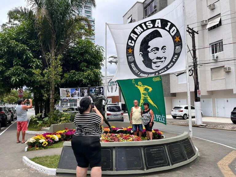 Visitantes tiram foto em estátua de Pelé em Santos.