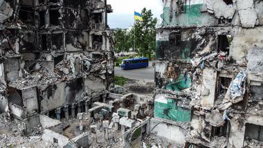 Ônibus passa em frente a prédio destruído em Borodianka, perto de Kiev; Ocidente ainda não sabe como iniciar negociações para o fim da guerra 
