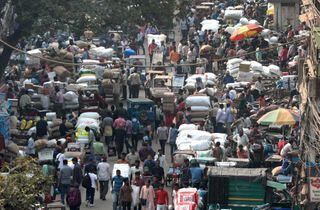 População caminha em rua congestionada de Nova Déli: Índia vai se tornar país mais populoso do mundo este ano 