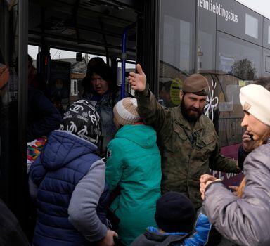 A Polish soldier gives directions to Ukrainian refugees upon their arrival at border crossing in Medyka, southeastern Poland, on Wednesday, March 30, 2022. The U.N. refugee agency says more than 4 million people have now fled Ukraine following Russia's invasion, a new milestone in the largest refugee crisis in Europe since World War II. (AP Photo/Sergei Grits)