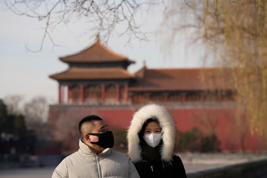 Moradores usam máscaras nas ruas de Pequim, em imagem desta quarta-feira, 14
