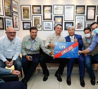 Bolsonaro segura cartão com a inscrição 'CPF cancelado' nos bastidores de gravação de programa de TV