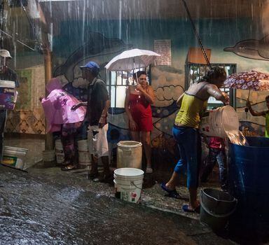 Moradores da favela Petare, a maior da Venezuela, estocam água da chuva em razão da forte seca que atinge o país