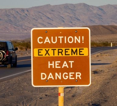 FURNACE CREEK, CALIFORNIA - JULY 15: A car passes a sign warning of extreme heat danger on the eve of a day that could set a new world heat record in Death Valley National Park on July 15, 2023 near Furnace Creek, California. Weather forecasts for tomorrow call for a high temperature of 129º Fahrenheit and possibly as high as 131. Previously, the highest temperature reliably recorded on Earth was 129.2F (54C) in Death Valley in 2013. A century earlier a high temperature in Death Valley reportedly reached 134F but many modern weather experts have rejected that claim along with other high summer temperatures reported in the region that year.   David McNew/Getty Images/AFP (Photo by DAVID MCNEW / GETTY IMAGES NORTH AMERICA / Getty Images via AFP)