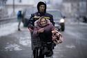 An elderly woman is carried in a shopping cart after being evacuated from Irpin, on the outskirts of Kyiv, Ukraine, Tuesday, March 8, 2022. (AP Photo/Vadim Ghirda)