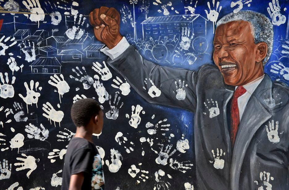 Garoto observa um mural com desenho do ex-presidente sul-africano Nelson Mandela em Johannesburgo, na África do Sul