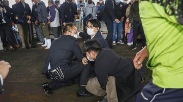 A man, on the ground, who threw what appeared to be a smoke bomb, is caught at a port in Wakayama, western Japan Saturday, April 15, 2023. Japan’s NHK television reported Saturday that a loud explosion occurred at the western Japanese port during Prime Minister Fumio Kishida’s visit, but there were no injuries. (Kyodo News via AP). Foto: Kyodo News via AP