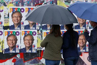 Pessoas caminham perto de cartazes do candidato à presidência da Colômbia, Gustavo Petro