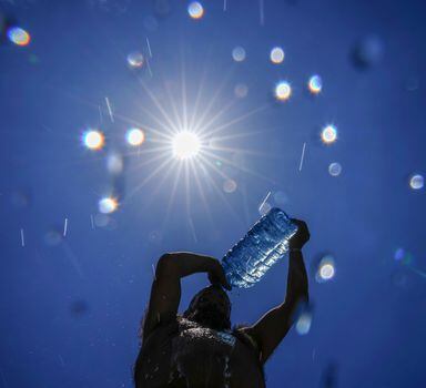 FILE - A man pours cold water onto his head to cool off on a sweltering hot day in the Mediterranean Sea in Beirut, Lebanon, Sunday, July 16, 2023. In the past 30 days, nearly 5,000 heat and rainfall records have been broken or tied in the United States and more than 10,000 records set globally, according to the National Oceanic and Atmospheric Administration. Since 2000, the U.S. is setting about twice as many heat records as cold. (AP Photo/Hassan Ammar, File)