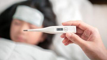 Asian mother holding digital thermometer with high temperature for check health her daughter, Sick child have cool gel for reduce high fever, Hand focus, Healthy and infection concept. Foto: Chanintorn.v/Adobe Stock 