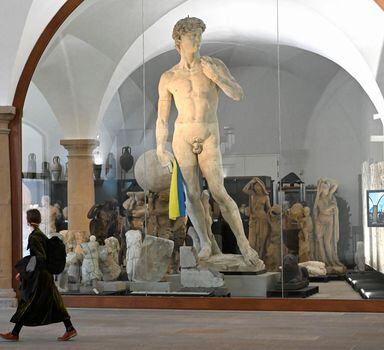 A Ukrainian flag is put in the hand of the Michelangelo's David cast, amid Russia's ongoing invasion of Ukraine, at the entrance area to the sculpture collection of the State Art Collections in Dresden, Germany, April 12, 2022. REUTERS/Matthias Rietschel