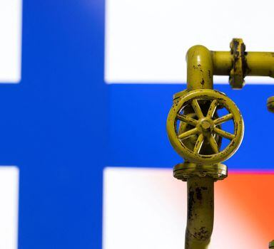 A model of the natural gas pipeline is seen in front of displayed Finnish and Russian flag colours in this illustration taken April 26, 2022. REUTERS/Dado Ruvic/Illustration