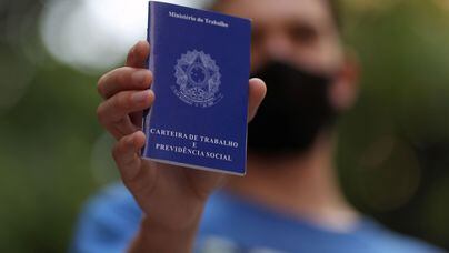 CARTEIRA DE TRABALHO AZUL  A man holds his work permit (employment record card) while looking for job opportunities in downtown Sao Paulo, Brazil, October 6, 2020. Picture taken October 6, 2020. REUTERS/Amanda Perobelli