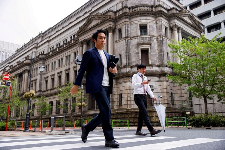 Pessoas caminham em frente ao prédio do Banco Central do Japão.
