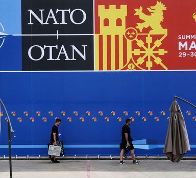 Technicians from TV walk past a poster announcing the NATO Summit inside the Madrid Fair before a NATO summit in Madrid, Spain, June 27, 2022. Nacho Doce/ REUTERS