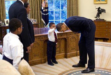 Então presidente Obama se inclina para que o pequeno Jacob Philadelphia possa tocar seu cabelo em encontro no Salão Oval, em 2009. Foto: Pete Souza/The White House via Washington Post