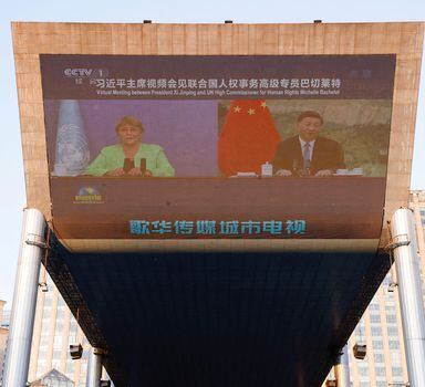 FILE PHOTO: Chinese President Xi Jinping and United Nations High Commissioner for Human Rights Michelle Bachelet are seen on a giant screen broadcasting news footage of their virtual meeting at a shopping complex in Beijing, China May 25, 2022. REUTERS/Carlos Garcia Rawlins/File Photo