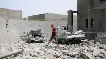 Líbio caminha pelos destroços de sua casa após ataque lançado pelas forças de Khalifa Haftar na região de Tajoura, ao leste de Trípoli. Foto: Hazem Ahmed/Reuters - 2019