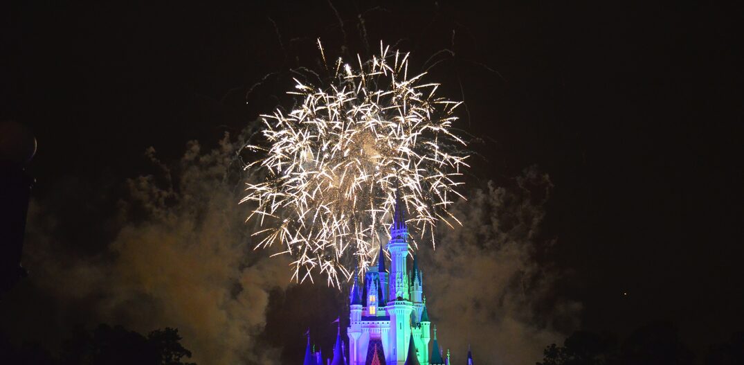 Magic Kingdom na Disney com o castelo iluminado a noite, mostrando o show de fogos. Foto: Unsplash