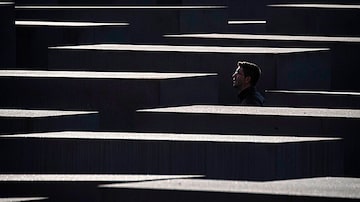 Visitante percorre as estelas de cimento do Memorial aos Judeus Mortos da Europa (Memorial do Holocausto), em Berlim, na Alemanha. Foto: John Macdougall / AFP