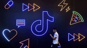 Visitantepassa por um painel com símbolo do aplicativo da empresa chinesa ByteDance, TikTok, conhecido localmente como Douyin, na International Artificial Products Expo, em Hangzhou, na China. Foto: Stringer / Reuters