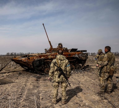 Soldados ucranianos rodeiam tanque russo abatido