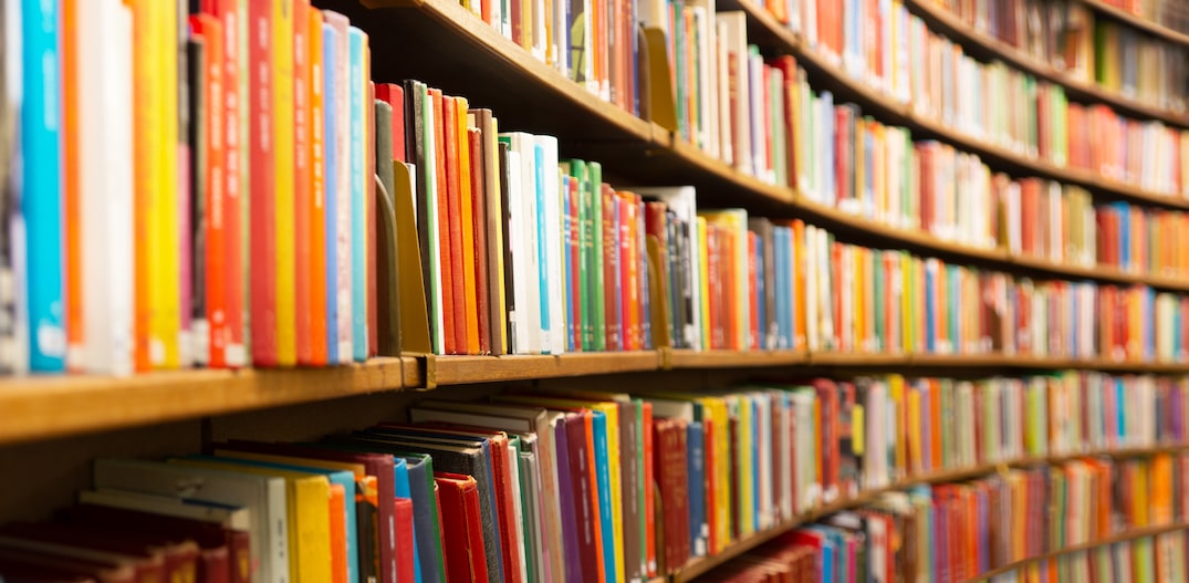 Livraria com estantes repletas de livros coloridos e variados. Foto: Pink Badger/AdobeStock