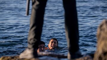 Soldado espanhol observa migrantes que completam a travessia entre Marrocos e Ceuta a nado. Foto: AP Photo/Bernat Armangue