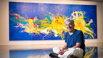 O pintor com a tela 'Onda', sua maisrecente pintura, feita na galeria do Sesi. Foto: TIAGO QUEIROZ/ESTADÃO