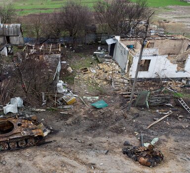 TOPSHOT - The wreckage of a tank is seen next to destroyed residential houses in the village of Zalissya, northeast of Kyiv on April 19, 2022. (Photo by Genya SAVILOV / AFP)
