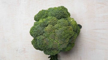Um ramo de brócolis sobre uma superfície lisa e clara. Foto: Daniel Teixeira|Estadão