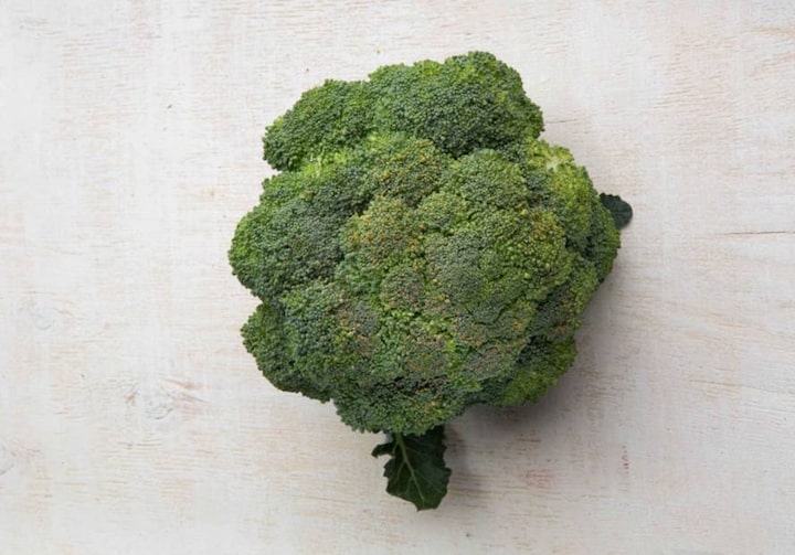 Um ramo de brócolis sobre uma superfície lisa e clara