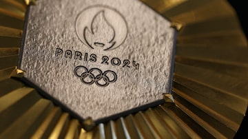 TOPSHOT - This photograph taken on January 30, 2024 in Paris shows the upcoming Paris 2024 Olympics gold medal designed by Fench luxury jewellery house Chaumet. On the medals' head side, the engraved figures of the goddess of victory Athena, Nike, the Panathenaic stadium and the Acropolis are imposed by the International Olympic Committee (IOC) but Paris 2024 has obtained exceptional authorization to add the design of the Eiffel Tower, and use 18 grams of Eiffel Tower metal on each medal, extracted from pieces of the tower. (Photo by Thomas SAMSON / AFP)