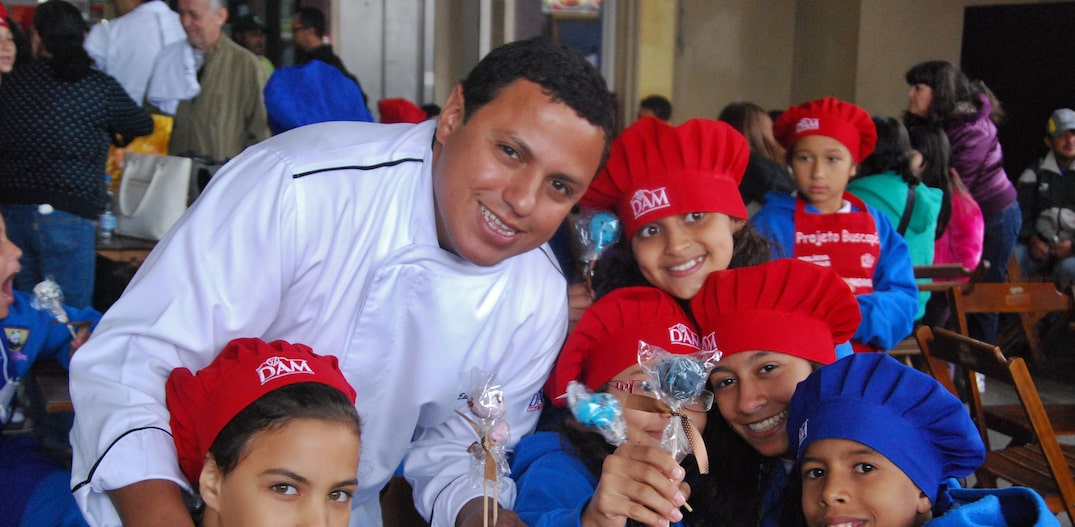 O chef Eudes Assis, curador do arraial, com crianças que participam do Projeto Buscapé. Foto: Projeto Buscapé