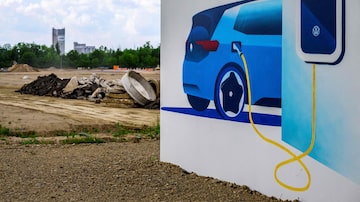 Mural de um carro elétrico da Volkswagen sendo carregado na Alemanha. Foto: John Macdougall/AFP