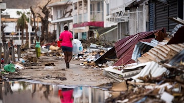 Moradora de Saint Martin caminha, entre escombros, por rua de Marigot; ilha tenta retomar rotina enquanto planeja recuperação. Foto: AFP PHOTO / Martin BUREAU