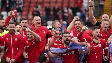 Wrexham players on the pitch celebrate promotion to League One after the final whistle of the Sky Bet League Two match at the SToK Cae Ras, Wrexham, Saturday April 13, 2024. (Jacob King/PA via AP). Foto: Jacob King/AP