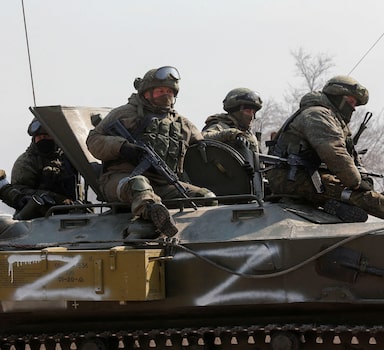 Service members of pro-Russian troops are seen atop of an armoured vehicle with symbols "Z" painted on its side in the course of Ukraine-Russia conflict in the besieged southern port city of Mariupol, Ukraine March 24, 2022. REUTERS/Alexander Ermochenko