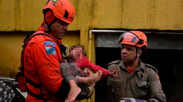TOPSHOT - Members of the Civil Defense carry a girl, who remained more than 12 hours under the rubble of her house, which was destroyed by the heavy rains in Petropolis, Brazil on March 23, 2024. At least nine people died in the midst of a strong storm that hits the southeast of Brazil, particularly the mountain area of the state of Rio de Janeiro, where authorities deployed a strong operation this Saturday in the face of a "critical" situation. The authorities reported three deaths in the collapse of a house in the city of Petropolis, about 70 kilometers from the capital of Rio, in a bulletin issued by an emergency committee formed by the government of Rio together with the Fire and Defense forces. (Photo by Pablo PORCIUNCULA / AFP). Foto: PABLO PORCIUNCULA