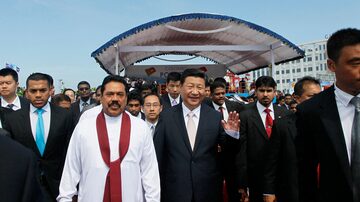 FILE - President Mahinda Rajapaksa, in white, walks with Chinese President Xi Jinping after officially launching a project to construct a $1.4 billion port city being built on an artificial island off Colombo, Sri Lanka, Wednesday, Sept. 17, 2014. China says its initiative to build ports and other infrastructure across Asia and Africa, paid for with Chinese loans, will boost trade. (AP Photo/Eranga Jayawardena, File). Foto: Eranga Jayawardena/AP