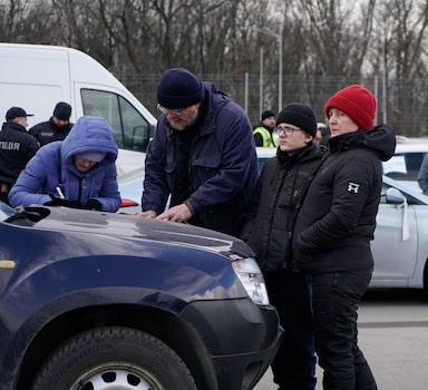 Evacuees from Mariupol are seen upon arrival at the car park of a shopping centre on the outskirts of the city of Zaporizhzhia, which is now a registration centre for displaced people, on March 16, 2022. - Some 20,000 residents have been allowed to leave Mariupol through a humanitarian corridor agreed with Russian forces. But exhausted, shivering evacuees speak of harrowing escape journeys and rotting corpses littering the streets. Mariupol is facing a humanitarian catastrophe according to aid agencies, since heavy bombardment has left some 400,000 inhabitants with no running water or heating and food running short. More than 2,100 residents have been killed in Mariupol since the Russian invasion, according to city authorities. (Photo by Emre CAYLAK / AFP)