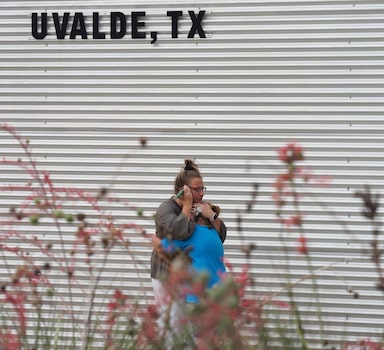 A woman cries and hugs a young girl while on the phone outside the Willie de Leon Civic Center where grief counseling will be offered in Uvalde, Texas, on May 24, 2022. - An 18-year-old gunman killed 14 children and a teacher at an elementary school in Texas on Tuesday, according to the state's governor, in the nation's deadliest school shooting in years. (Photo by Allison Dinner / AFP)